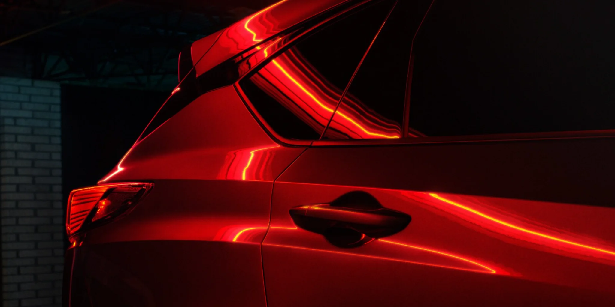 2026 Acura RDX Rear Quarter Detail Rear quarter detail of a 2026 Acura RDX under red accent lighting