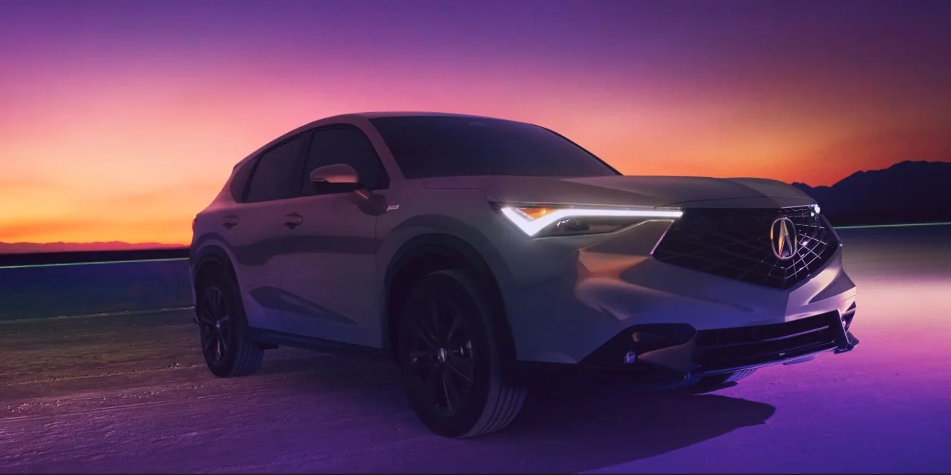 White 2026 Acura ADX parked under a purple and orange sunset sky