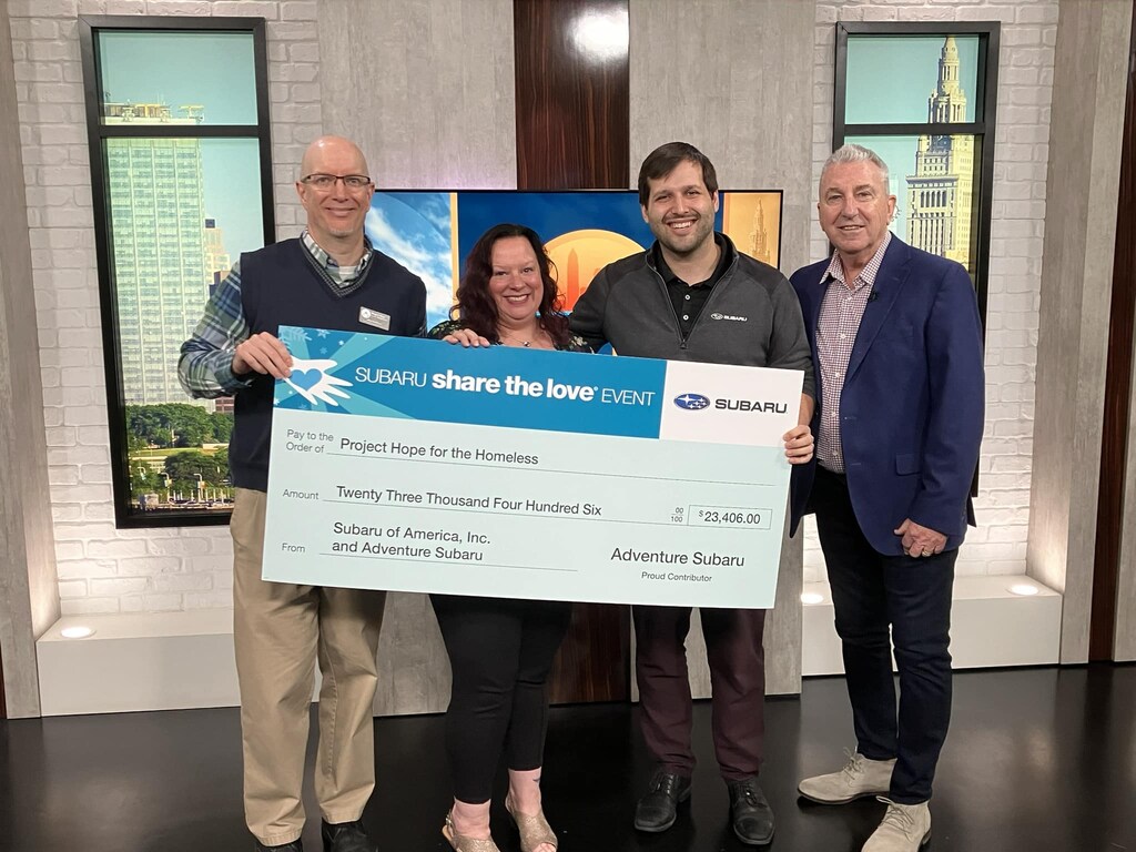 Adventure Subaru and Project Hope for the Homeless representatives holding a Subaru Share the Love check on Fox 8's New Day Cleveland set.