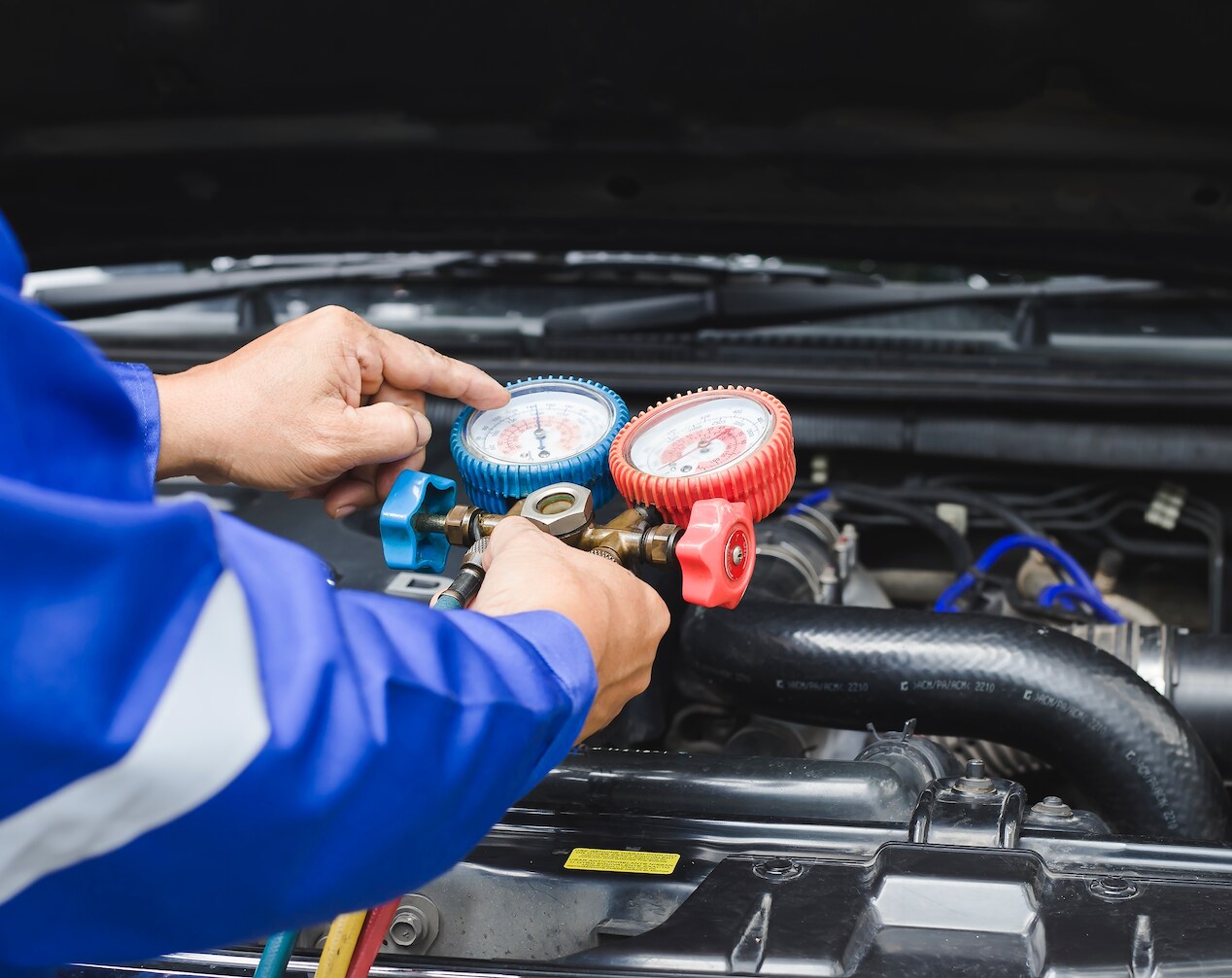Alfa Romeo certified technician repairing air conditioner.