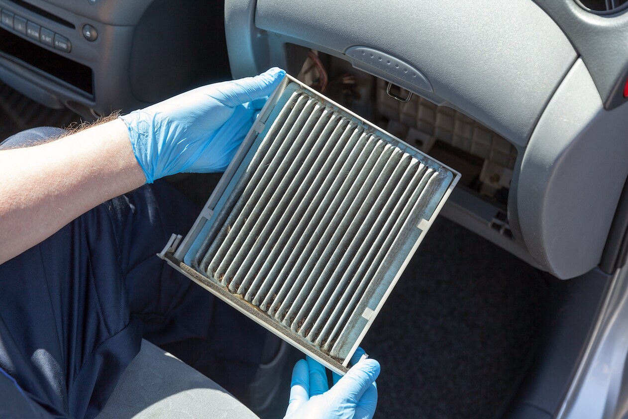 Alfa Romeo Certified Tech removing dirty cabin air filter.