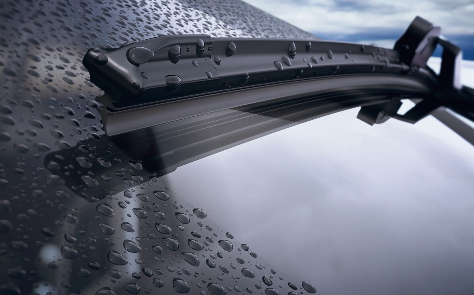 Windshield wiper removing water from windshield.