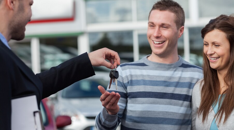 Couple getting keys to new car