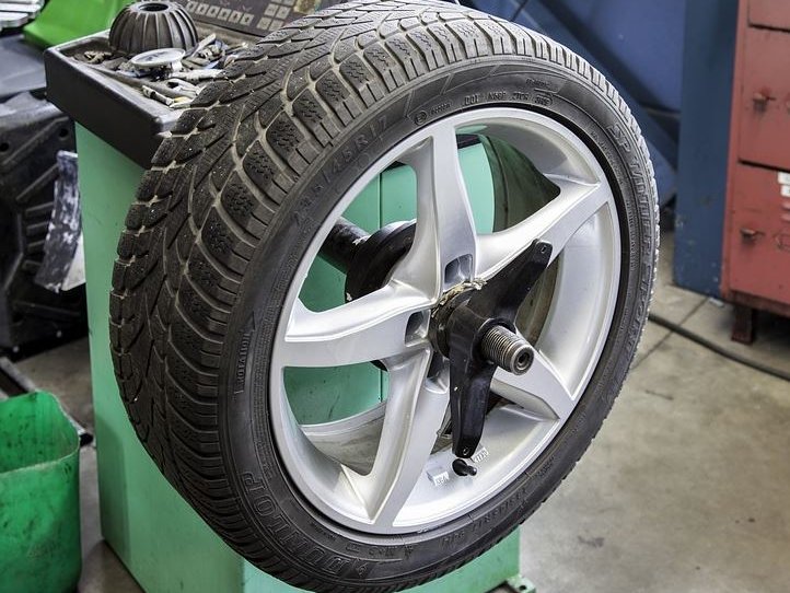 image of wheel and tire on balancing machine in the tire shop