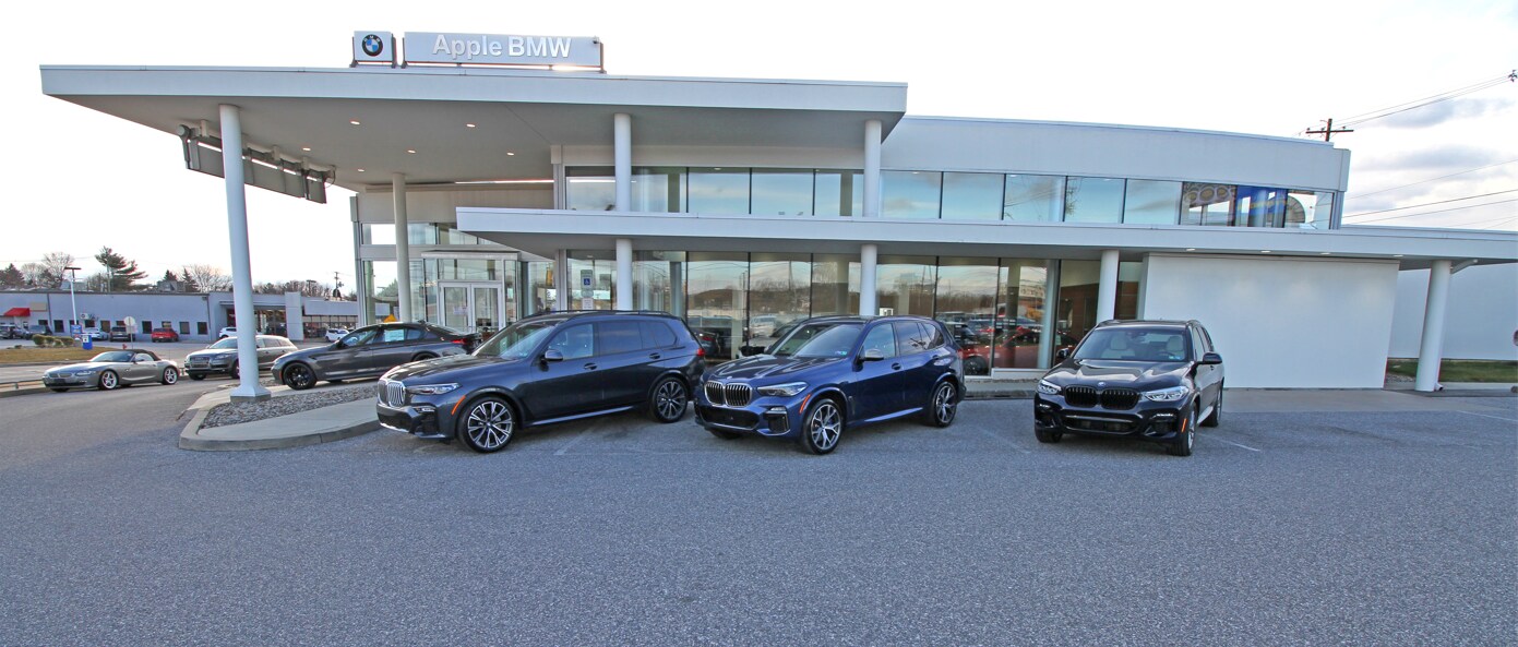 Exterior view of Apple BMW dealership located in York, Pennsylvania, showcasing a selection of BMW vehicles in the foreground.