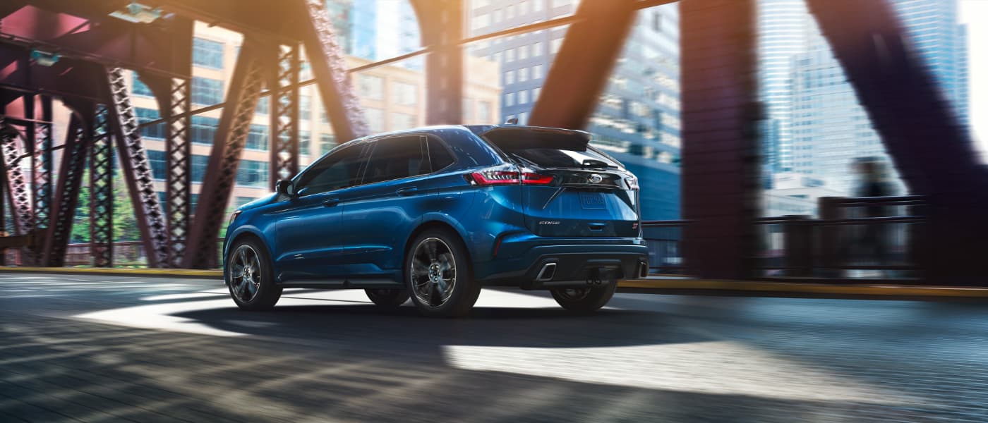 New 2020 Blue Ford Edge driving on a bridge side exterior view