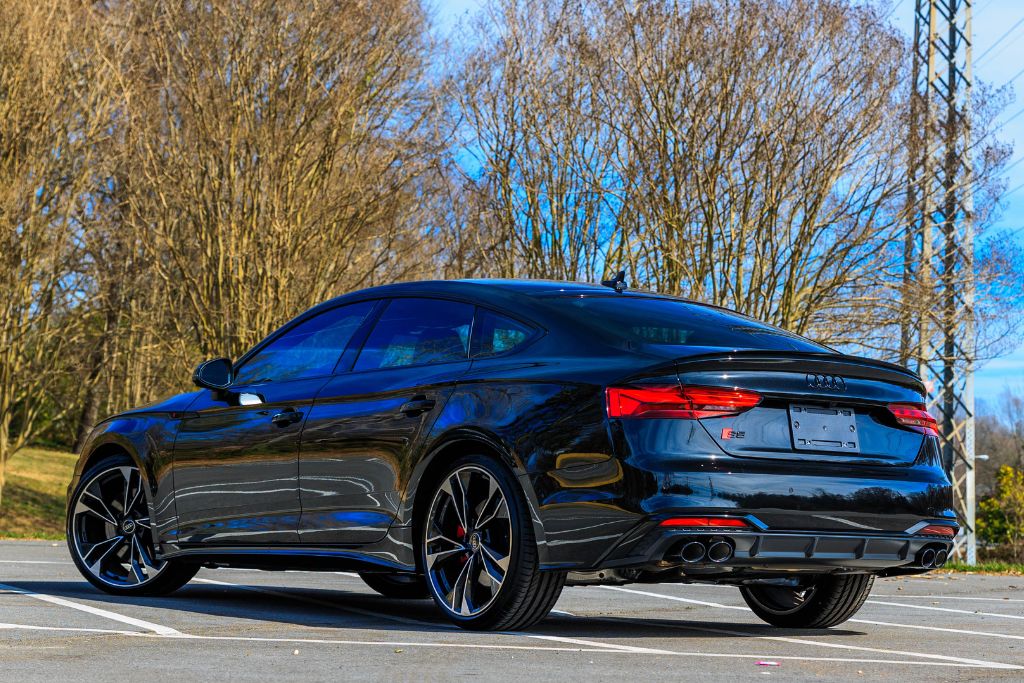 2024-audi-s5-sportback.jpg Rear view of Audi S5 for sale in Asheville, NC parked in a lot with trees and blue sky in background