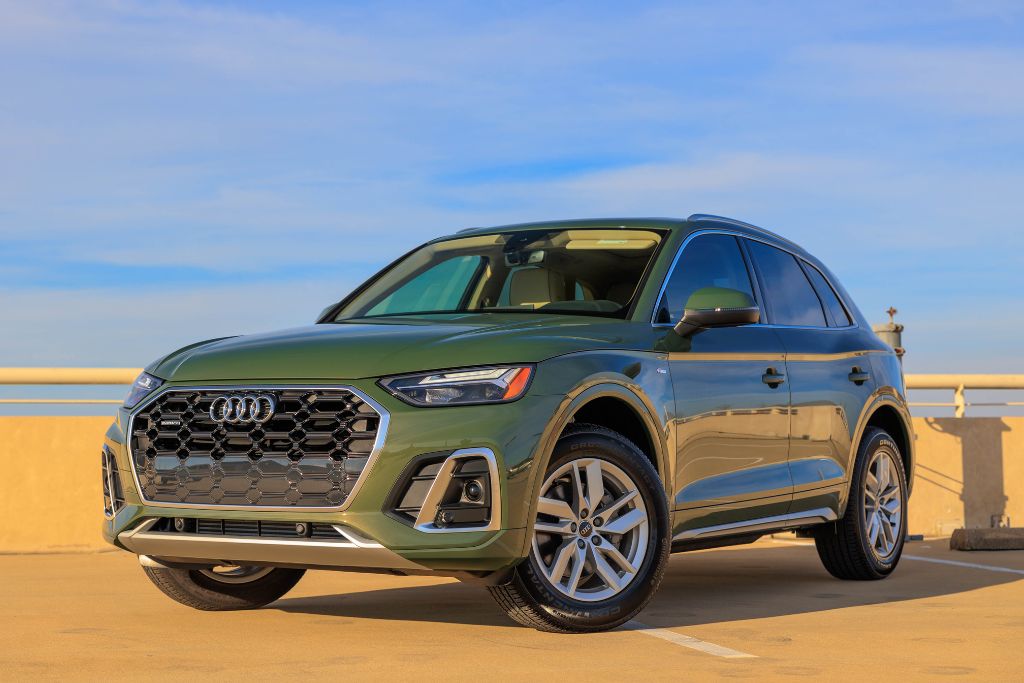 audi-q5-asheville-nc.jpg 2024 Audi Q5 for sale shown in a district green exterior color, front view of SUV parked diagonally with blue sky in background