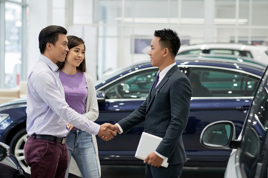 audi-service-maintenance-asheville.jpg Men shaking hands in front a car, seemingly closing deal at a car dealership