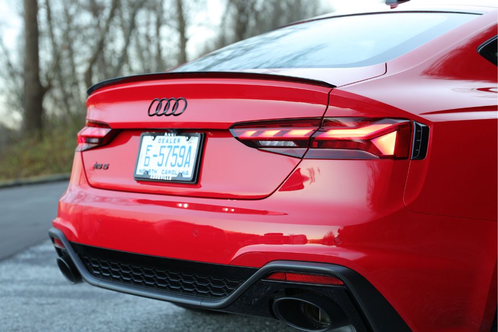 audi-rs5-for-sale.jpg Rear view of an Audi RS5 sportback, shown in red, with a North Carolina dealer tag and Audi Asheville license plate holder, parked in road