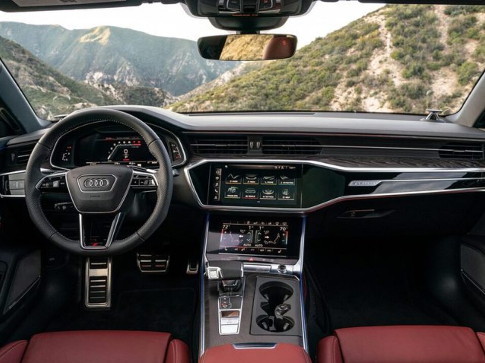 2023 Audi S6 interior.png black and red Audi S6 interior dashboard and steering area overlooking hills