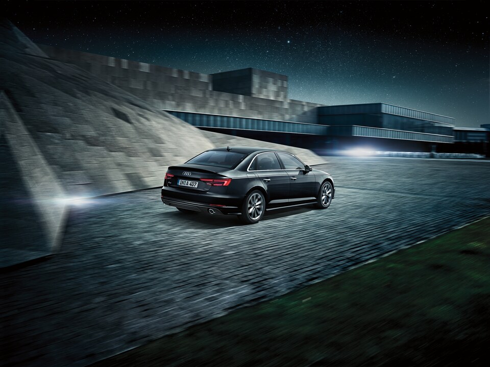 2017-Audi-A4-Premium-Sedan-L04.png black Audi A4 sedan driving on a cobblestone road next to a cobblestone rise