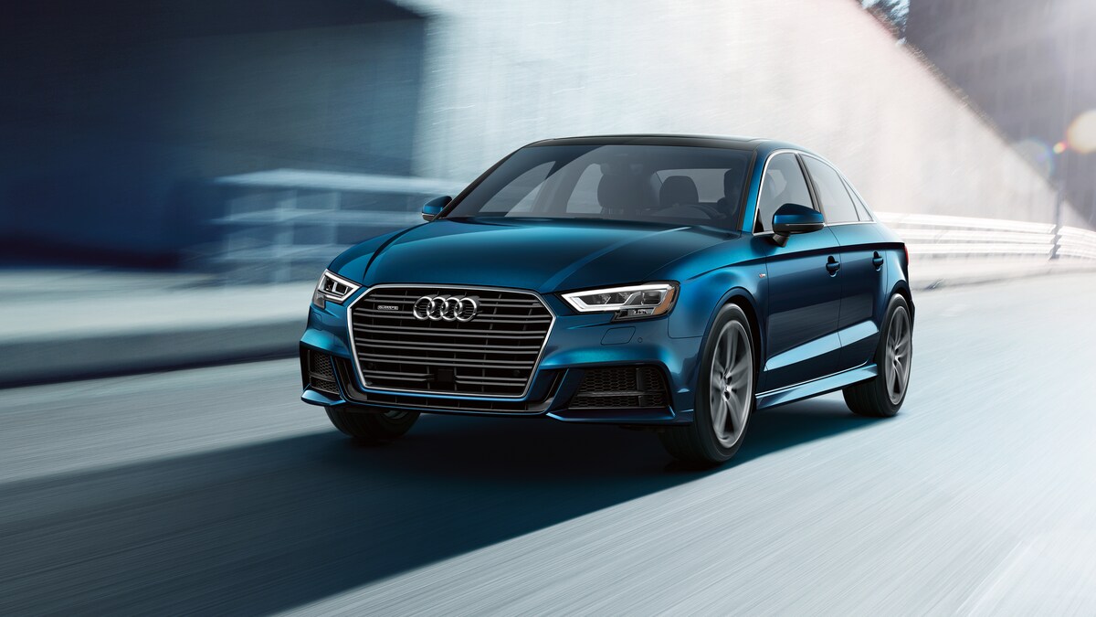 2021-Audi-A3-SLine-PremiumPlus-WheelAddOn-Sedan-L02.png blue Audi A3 sedan driving by an underpass, background blurred
