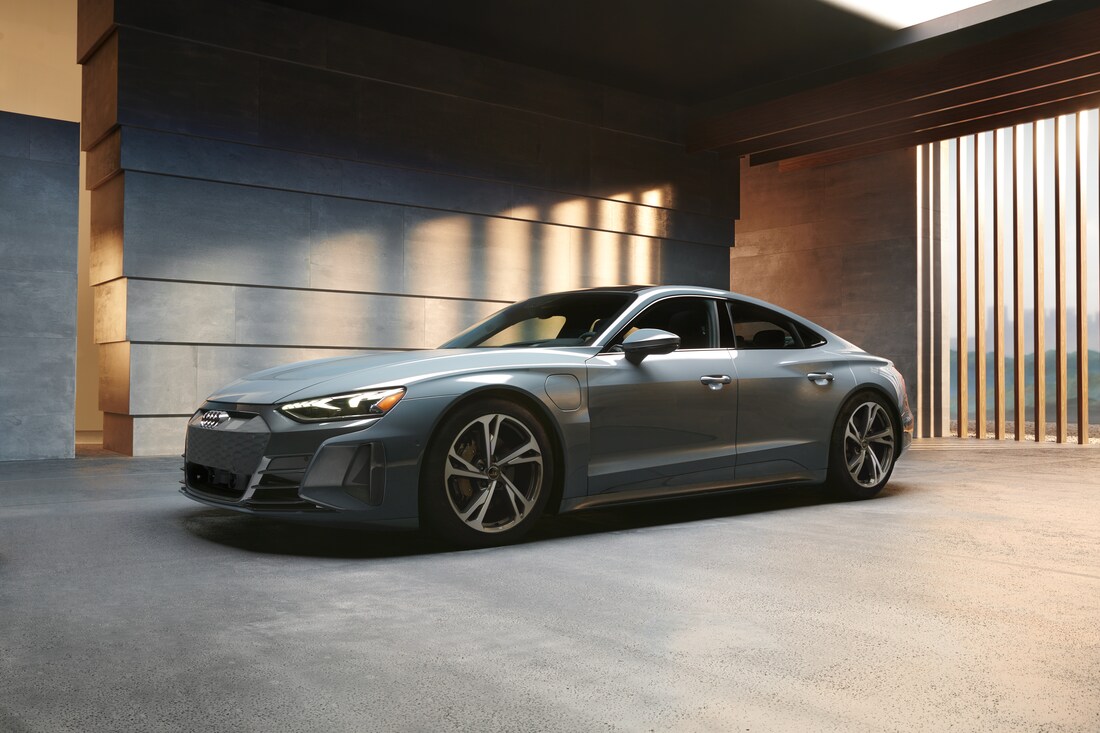 2022-Audi-etronGT-Base-Prestige-Sedan-L15.png gray Audi e-tron GT sedan parked in a modern building