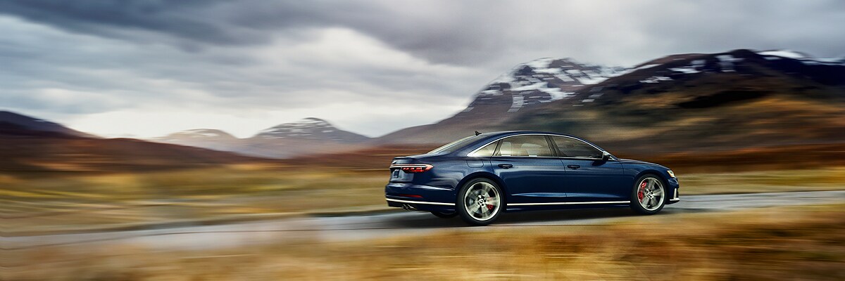 Audi S8 Audi S8 driving away on a road in the mountains