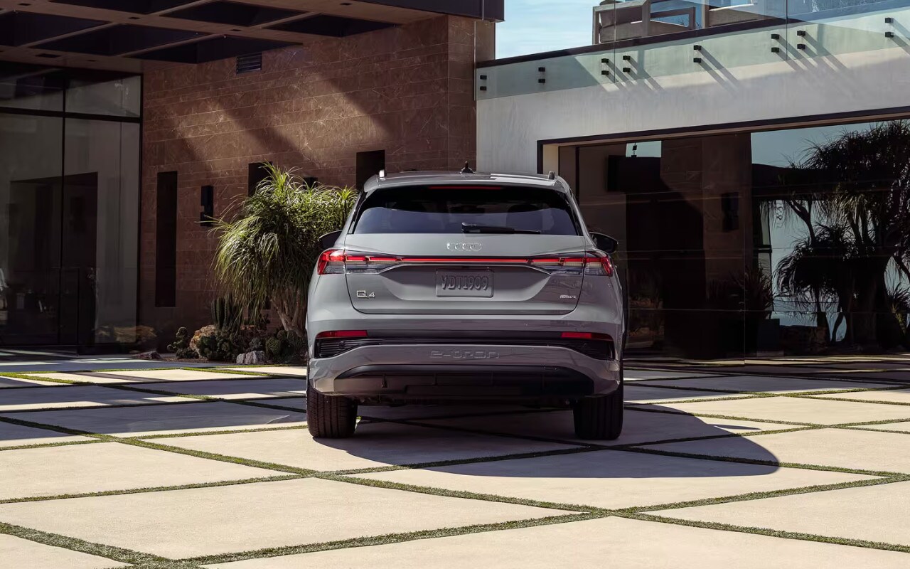 vue arrière d'une Audi Q4 E-tron 2024 devant un bâtiment au design moderne