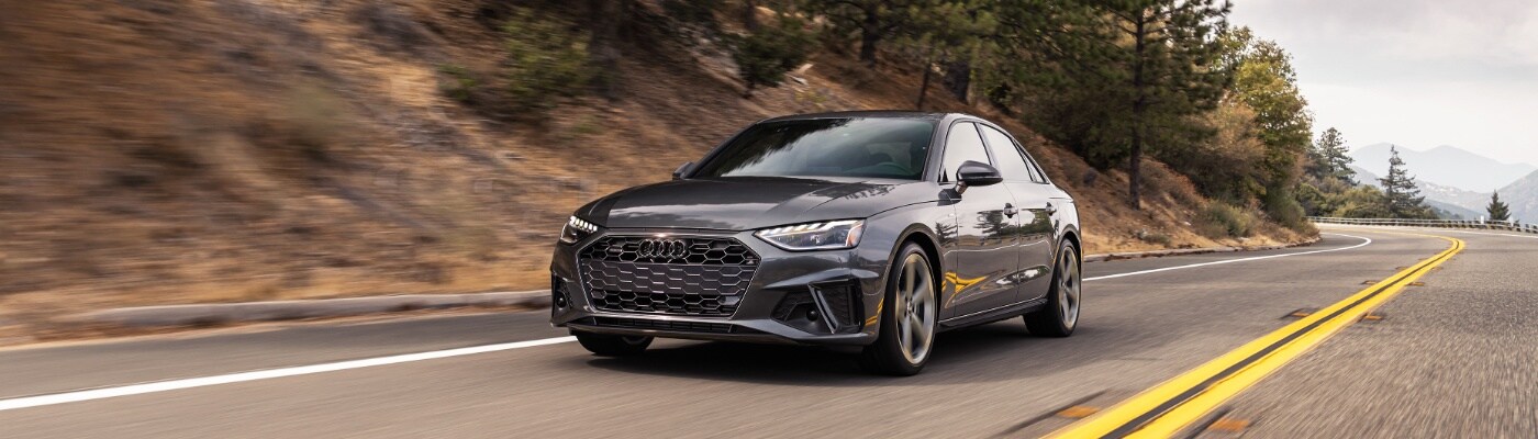 Audi A4 Gray A4 sedan driving on a mountain side road