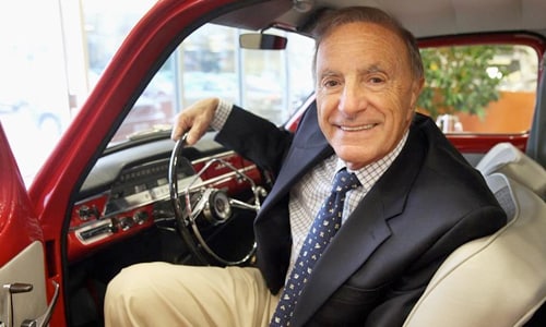 Ray Ciccolo smiling sitting in an old red vehicle