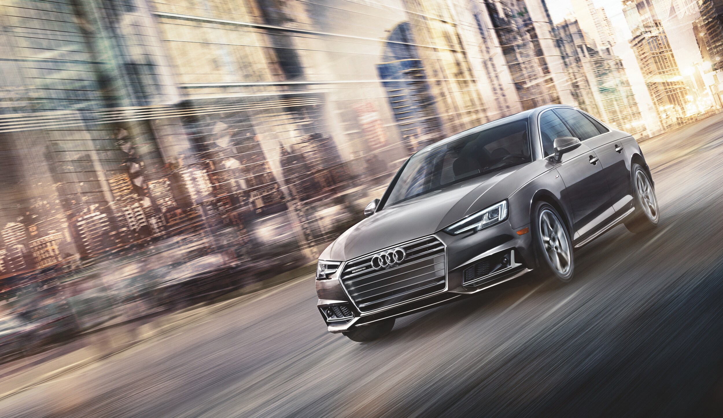 MY18 A4 Ext 2.0T quattro Prestige Driving City Streets Front Angle_Manhattan Gray metallic.jpg