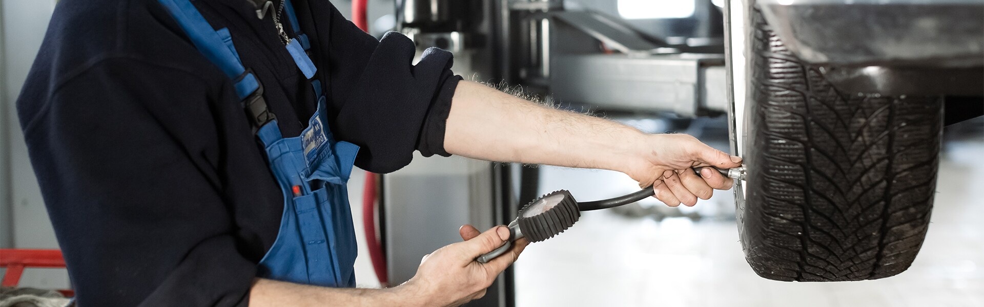 3 Main Benefits of Using OEM parts for your vehicle at Audi Owings Mills of Owings Mills | Service Tech Checking Tire Pressure on Vehicle's Tire