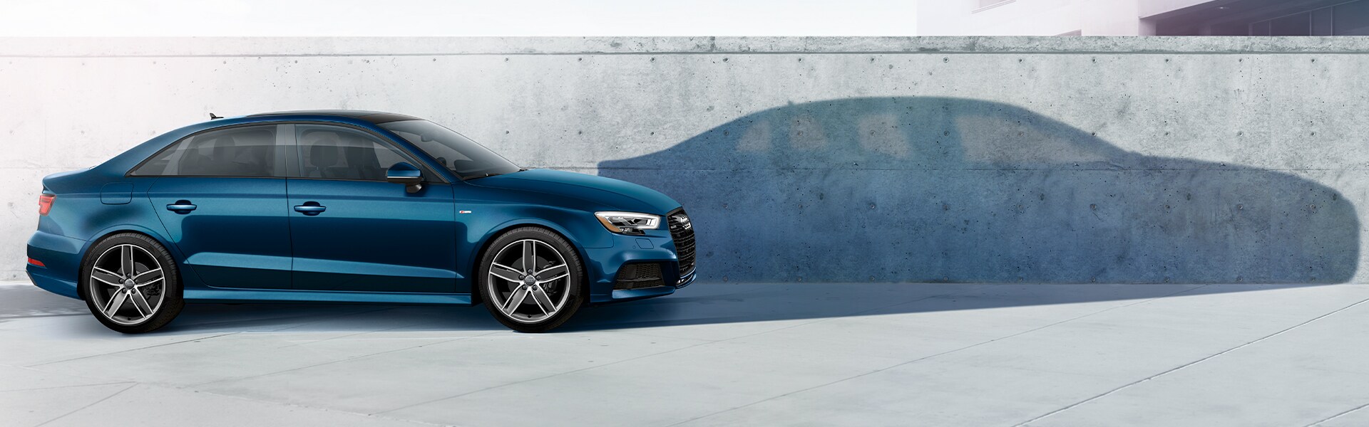 the 2020 Audi Q3 vs. the 2020 Mercedes-Benz GLA at Audi Owings Mills | Side Profile Shot of a Blue 2020 Audi A3 with Dark Shadow on the Wall Behind it the 2020 Audi Q3 vs. the 2020 Mercedes-Benz GLA at Audi Owings Mills | Side Profile Shot of a Blue 2020 Audi A3 with Dark Shadow on the Wall Behind it