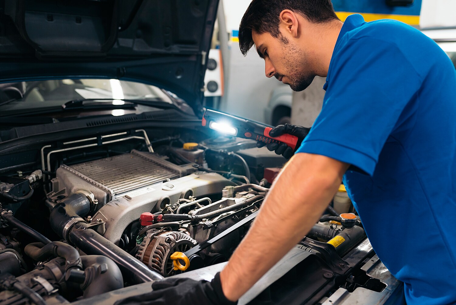 Audi Owings Mills is a Car Dealership in Pikesville near Owings Mills MD | Mechanic looking under hood of car