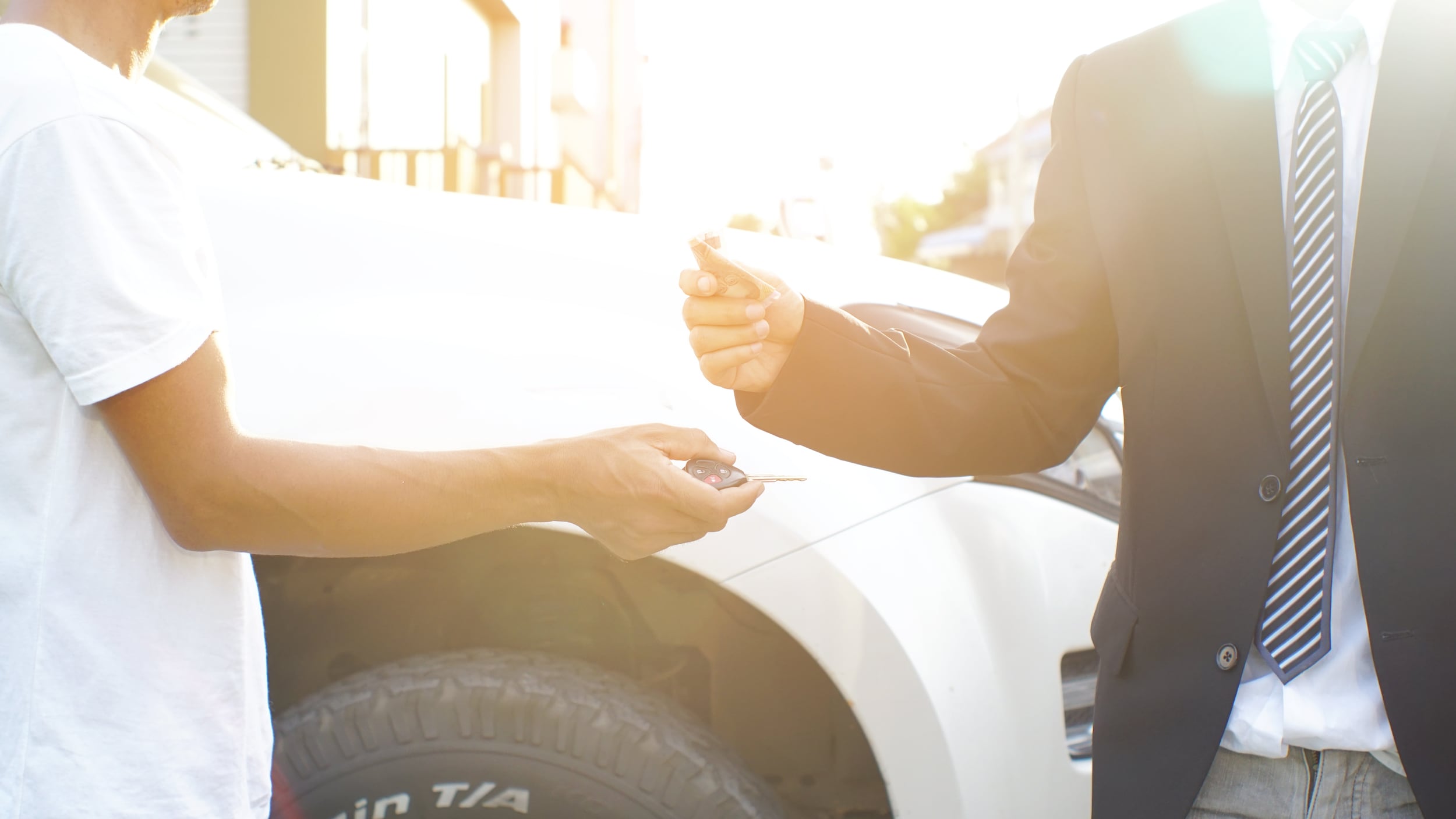 luxury_car_trade_in.jpg Man trading luxury car for money
