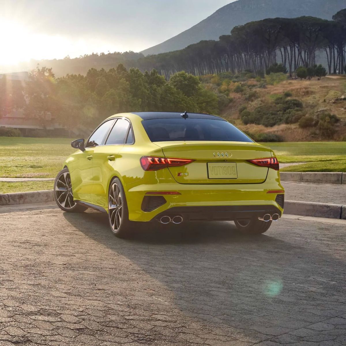 Vue 3/4 arrière d'une berline Audi S3 2022 Jaune Python Métallisé garée à l'extérieur