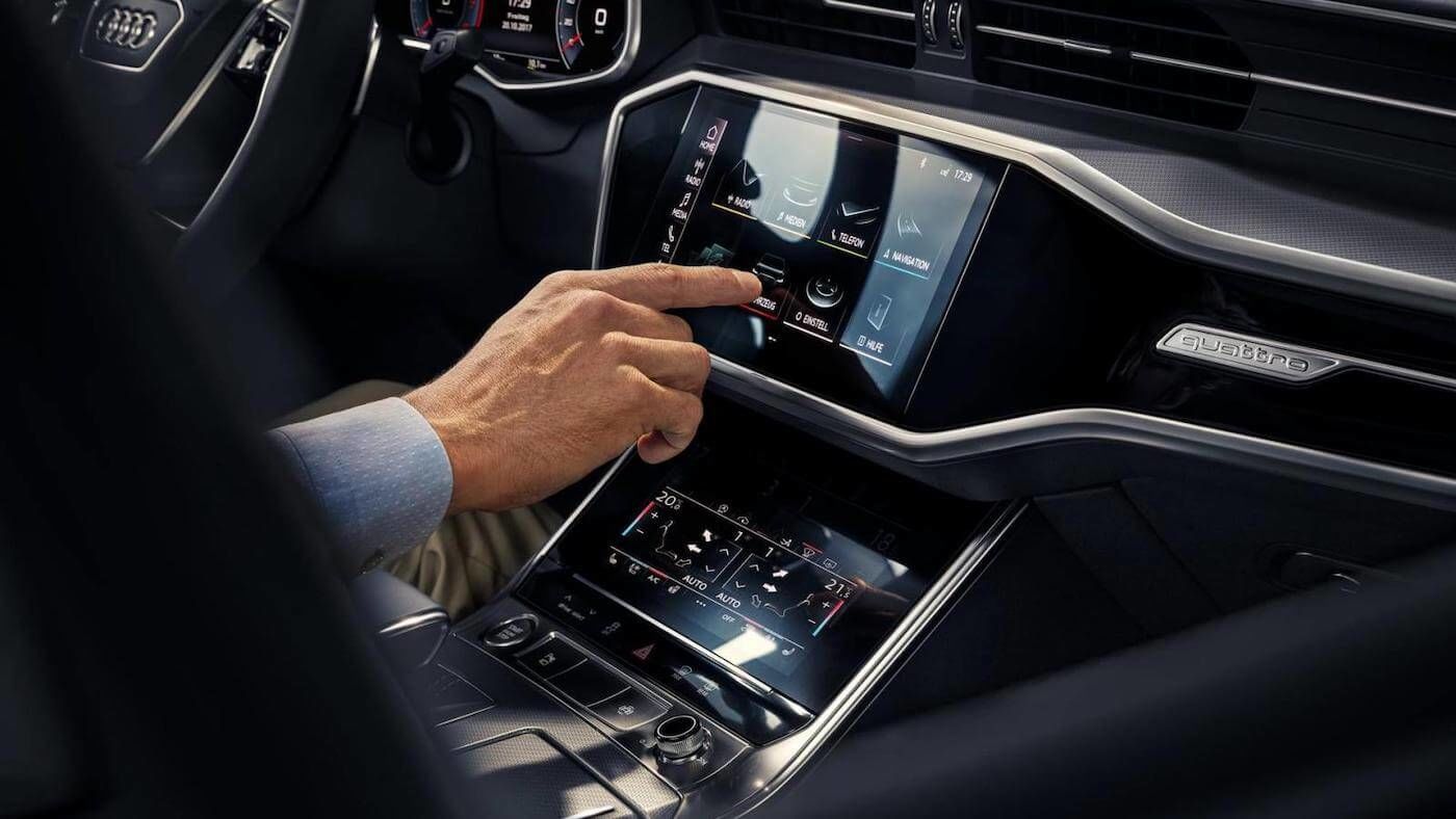 Propriétaire au volant d'un Audi utilisant le pavé tactile MMI touch d'Audi Connect.