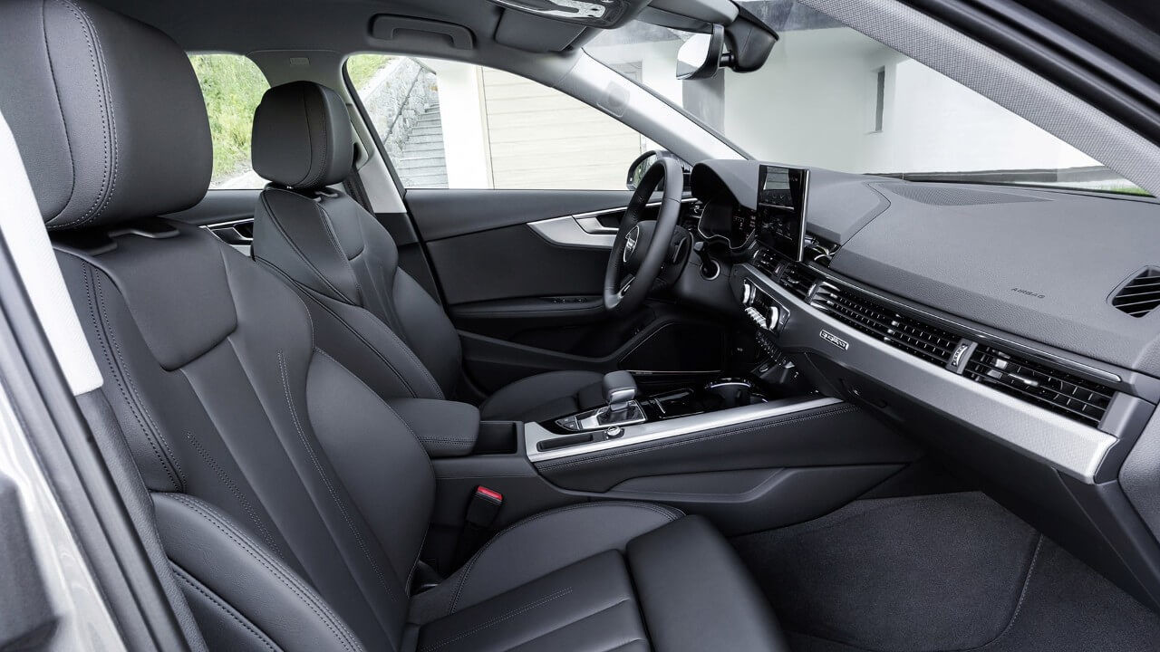 Perspective de vue du passager avant de l'intérieur avant d'une berline Audi A4 incluant sa planche de bord et ses sièges