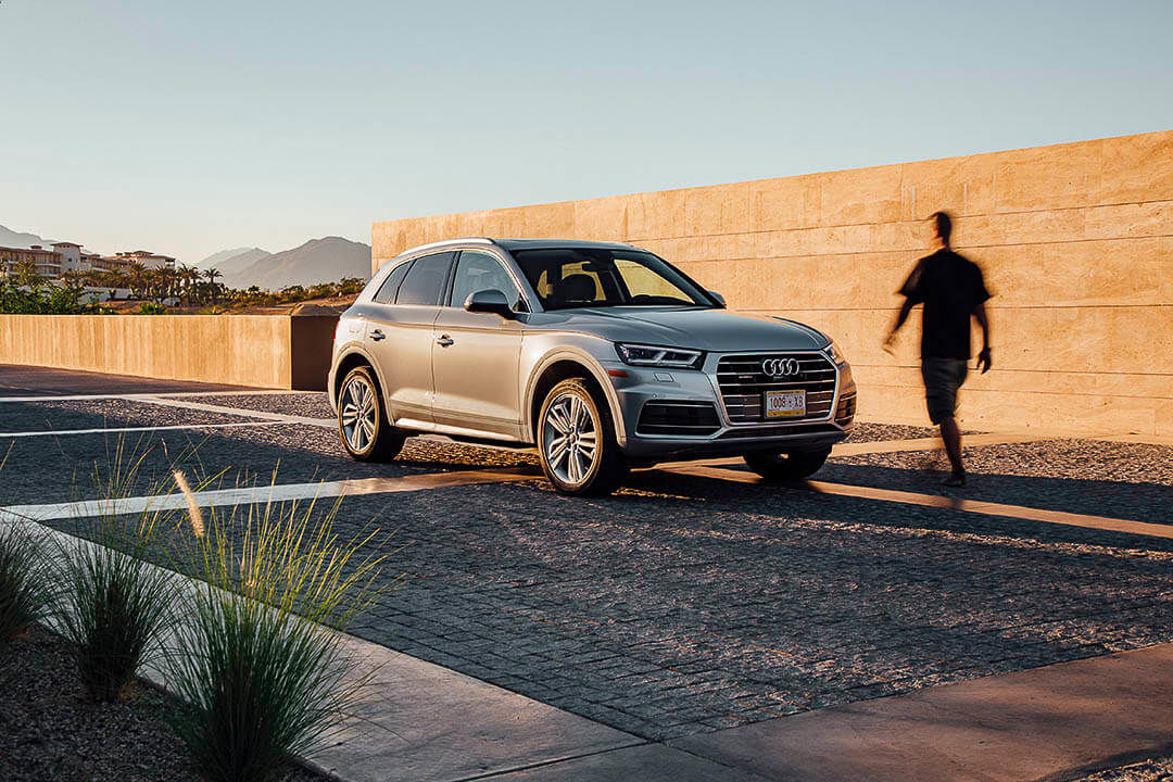 Vue 3/4 avant d'un VUS Audi Q5 2018 avec l'ombre du conducteur se dirigeant vers le véhicule