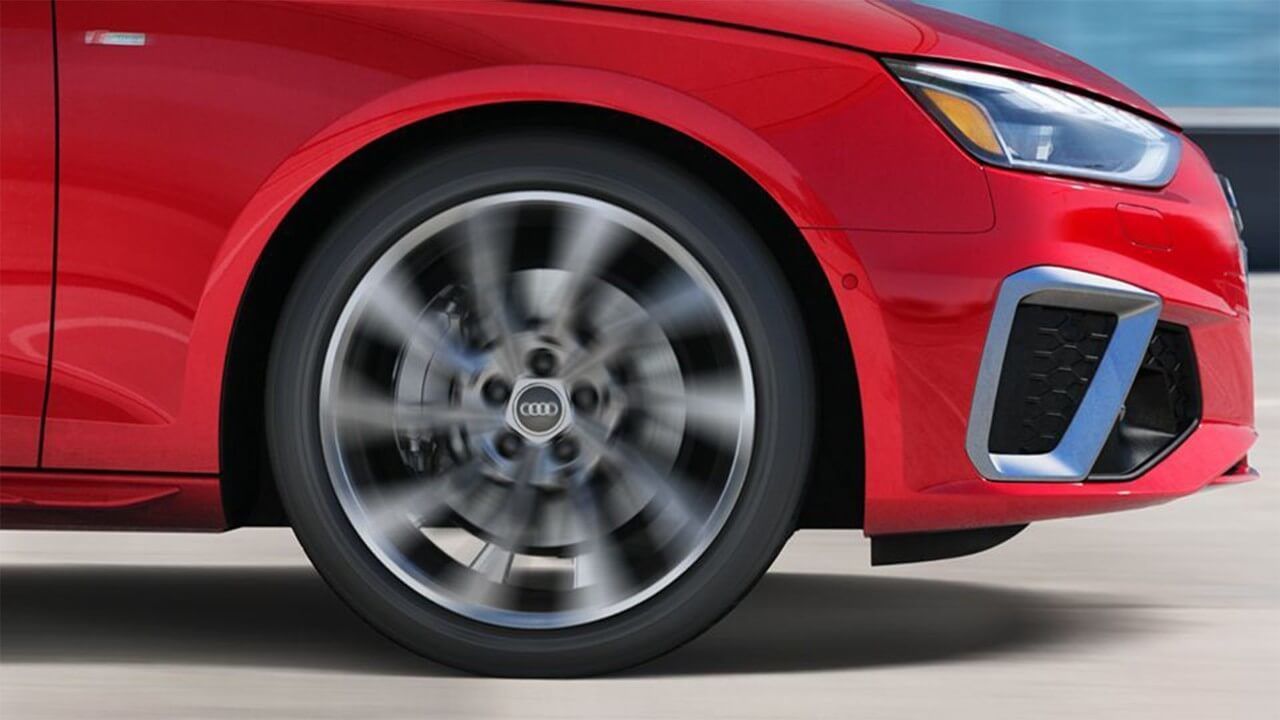 Roue avant droite d'une berline Audi A4 rouge en action