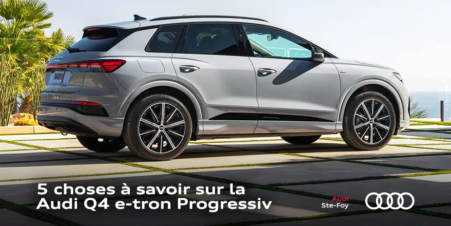 Vue latérale et 1/4 arrière de l’Audi Q4 e-tron Progressiv 2023 à l'extérieur.