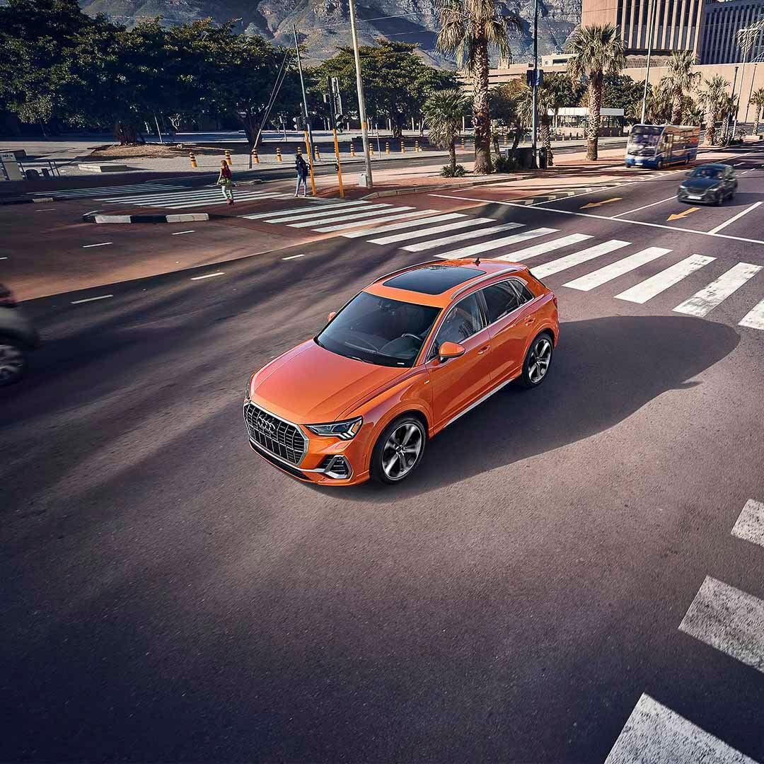 Audi Q3 Vue de dessus d'un VUS Audi Q3 de couleur orange roulant sur un boulevard en ville