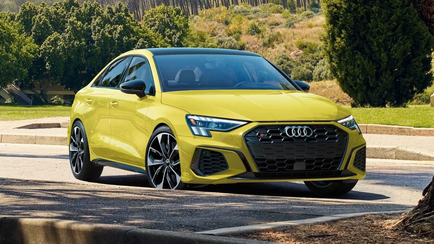 Vue 3/4 avant d'une berline Audi A3 2022 Jaune Python Métallisé garée à l'extérieur