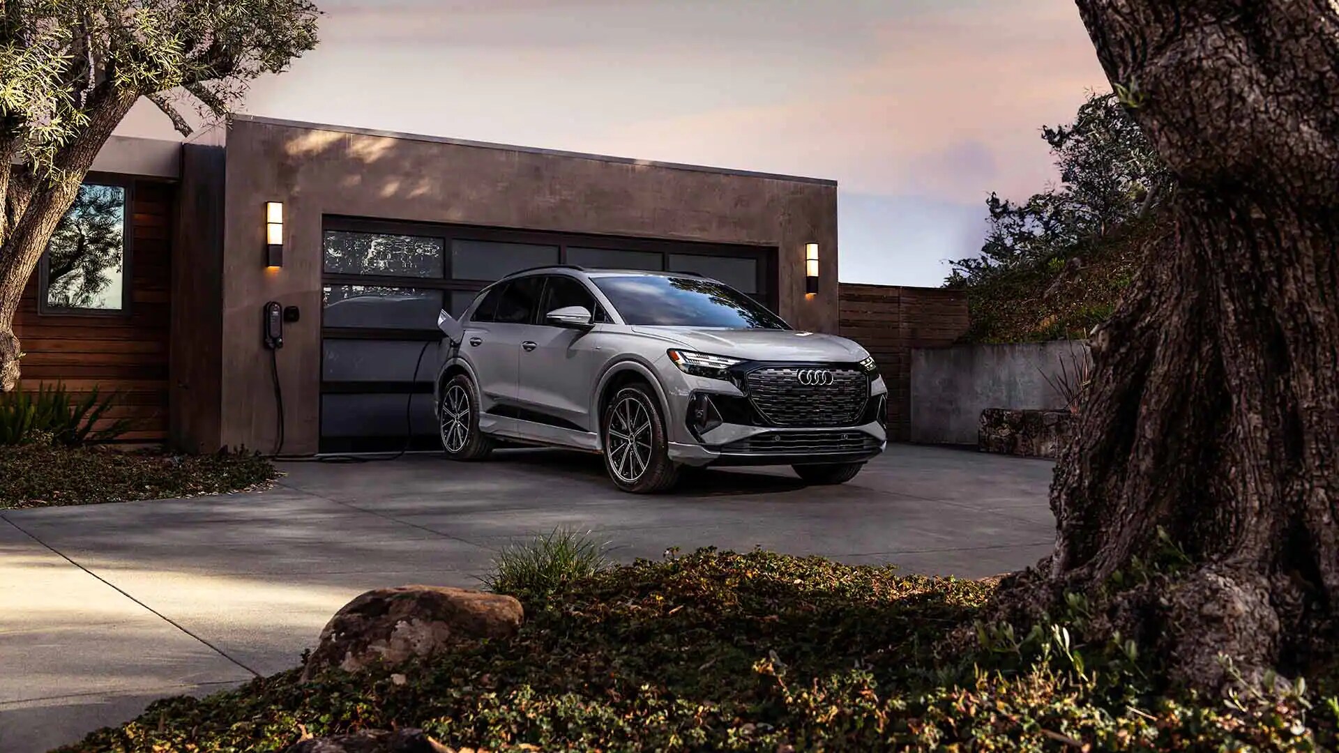 Profil avant aux trois quarts de l'Audi Q4 e-tron 2023 en recharge à la maison.