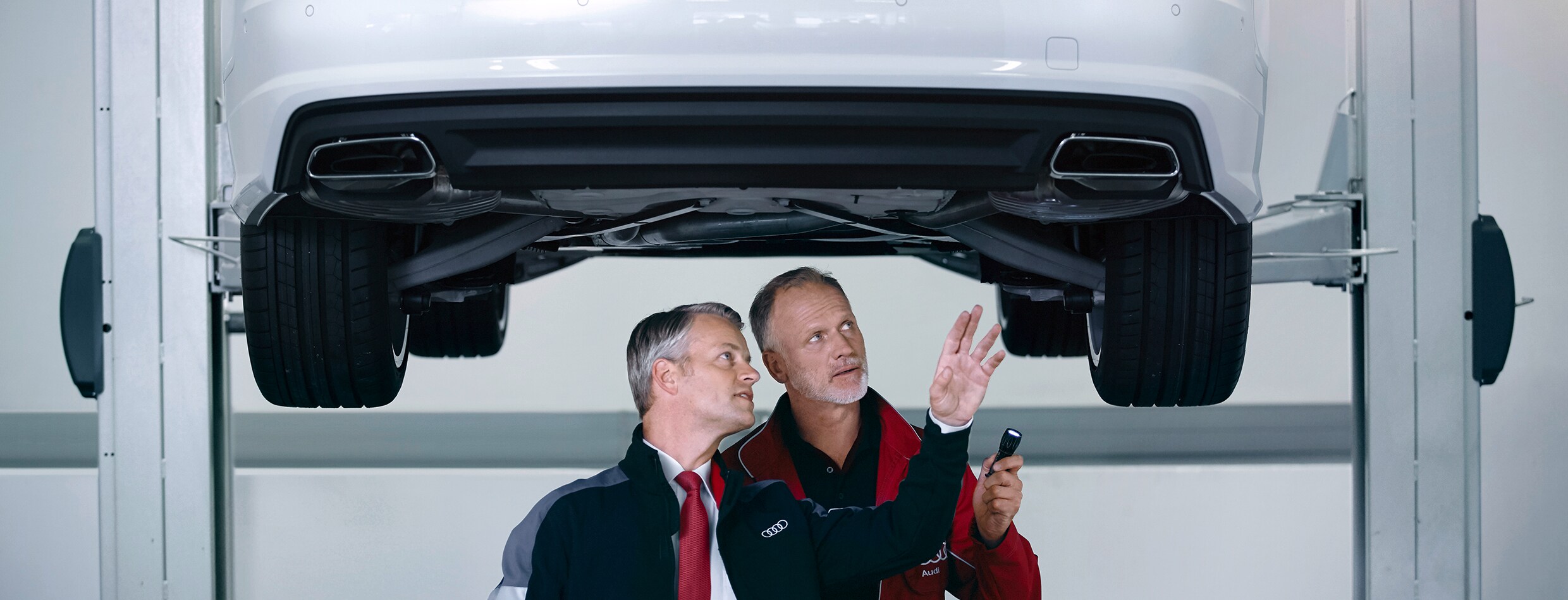 two technicians servicing a car