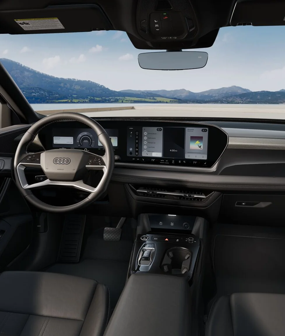 Audi Q6 e-tron cockpit with the steering wheel and curved displays