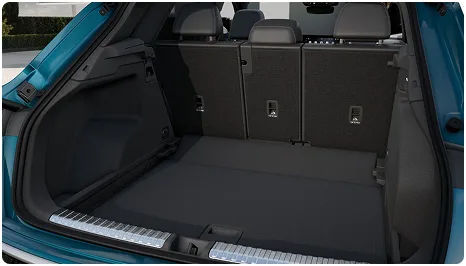 Open cargo area of the teal Audi Q3 with the rear seats upright