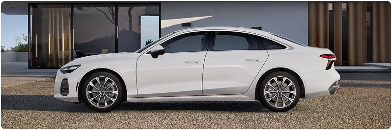 White Audi A6 Sedan in profile outside a modern house