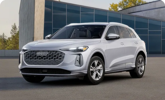 White 2026 Audi Q5 Premium parked outside a glass-walled building