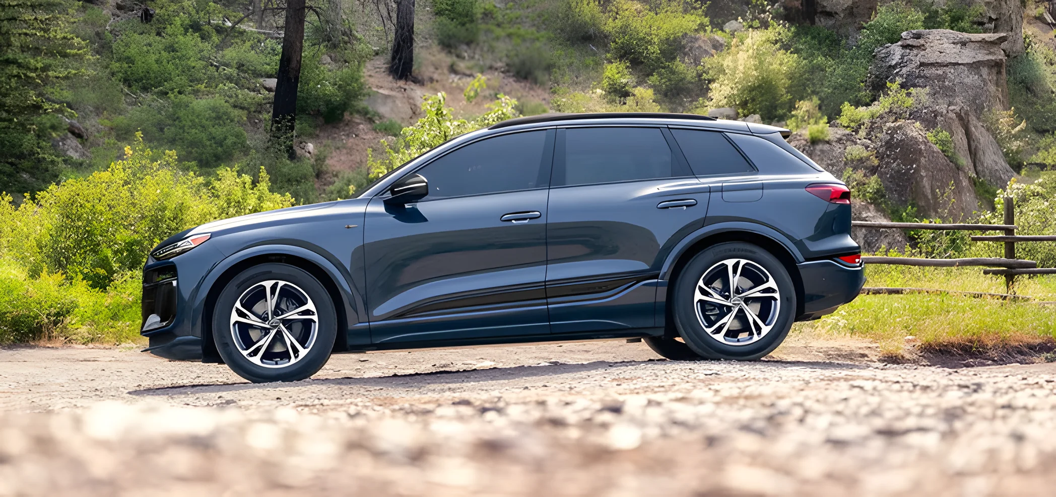 Blue Audi Q6 e-tron with the S line black optic package in profile on a mountain road