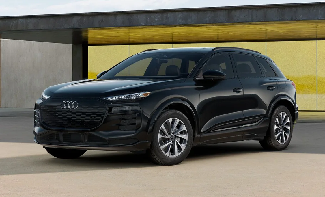Black 2027 Audi Q6 e-tron Premium Plus parked in front of a yellow wall