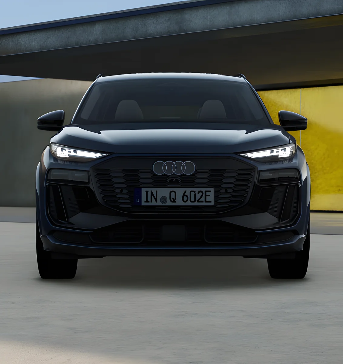 Front of a black Audi Q6 e-tron with its LED headlights lit