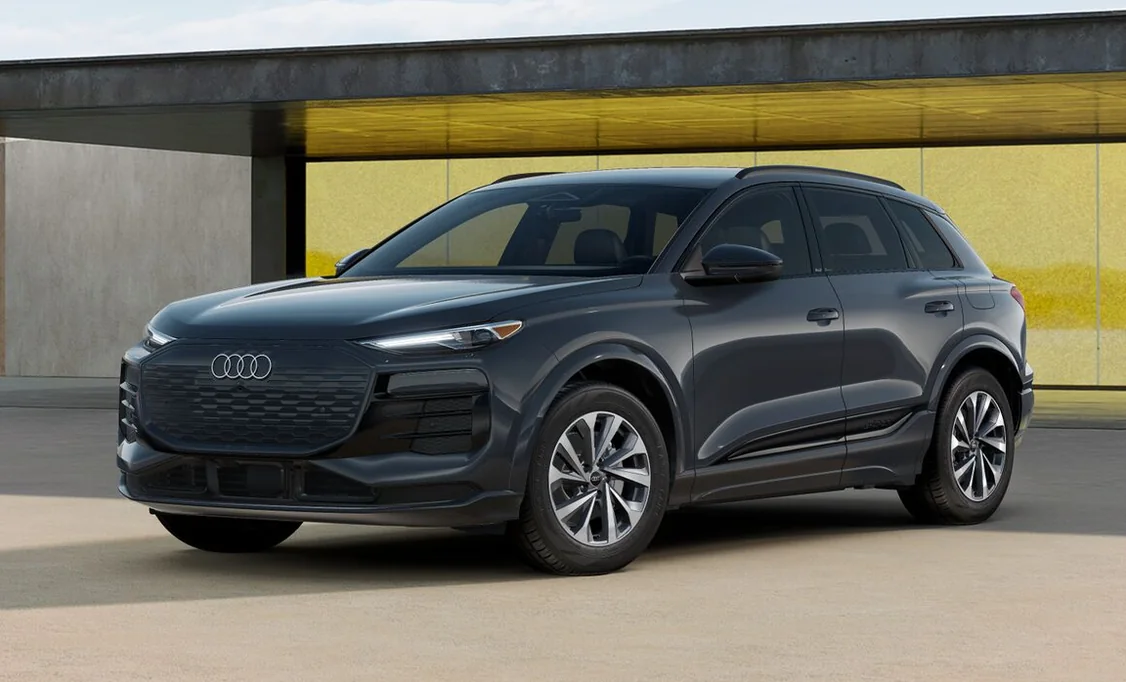 Grey 2027 Audi Q6 e-tron Premium parked in front of a yellow wall
