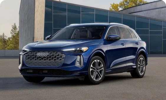 Blue 2026 Audi Q5 Prestige parked outside a glass-walled building