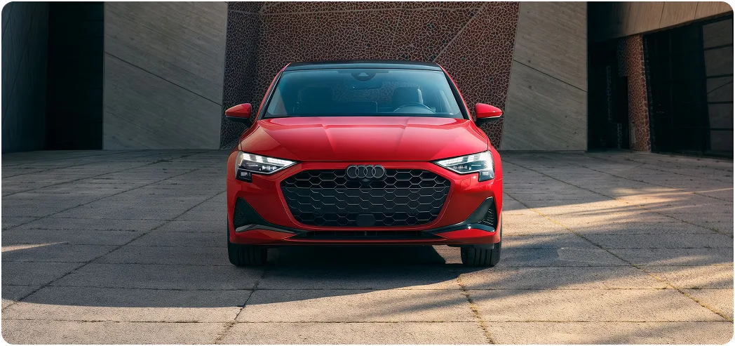 Red Audi A3 photographed head-on showing its black optic trim and Singleframe grille
