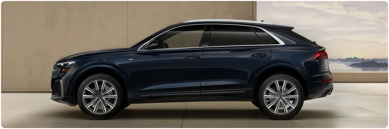 Blue Audi Q8 seen in profile in a bright stone-walled studio
