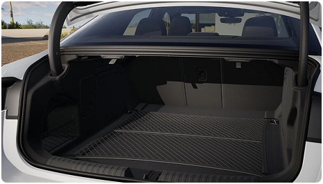 Open trunk of a white Audi A6 Sedan with a cargo net across the floor