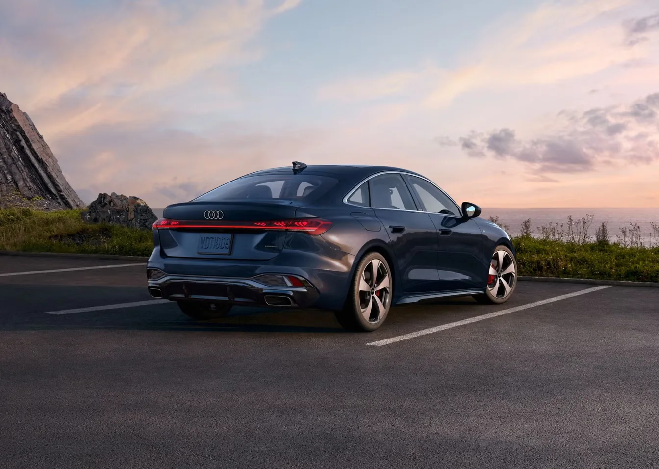 Rear three-quarter view of a blue Audi A5 showing its sweeping roofline at dusk